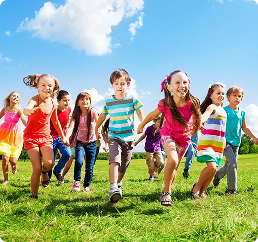 A group of children running in the grass.