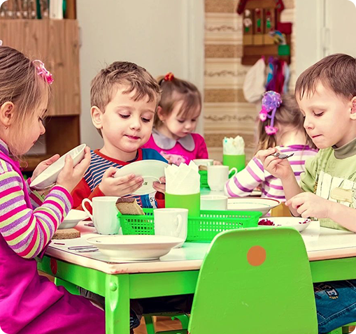 A group of children sitting at a table eating.