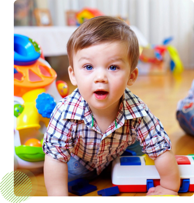 A young boy is playing with toys on the floor.