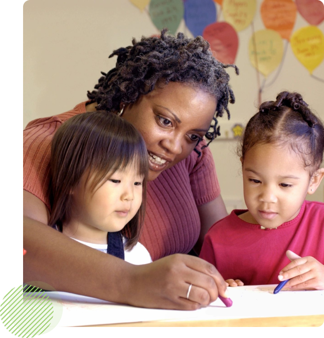 A woman and two children are drawing on paper.