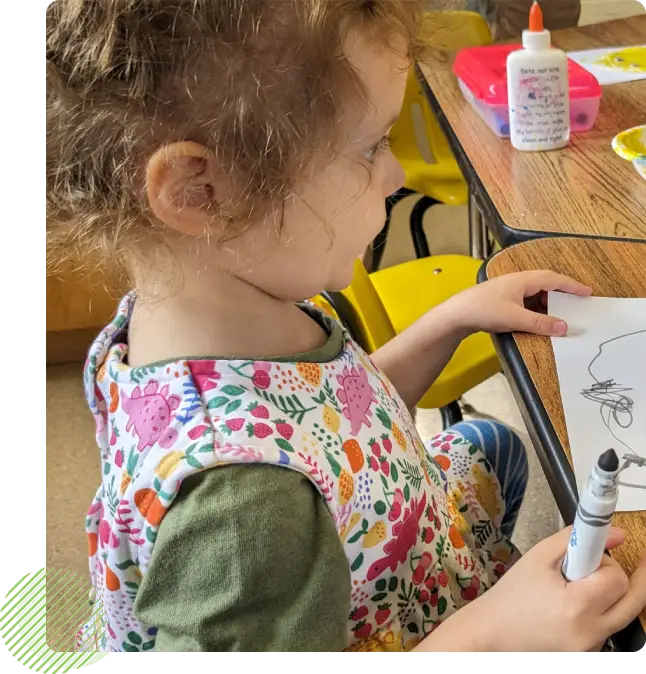 A child is holding a marker and drawing.