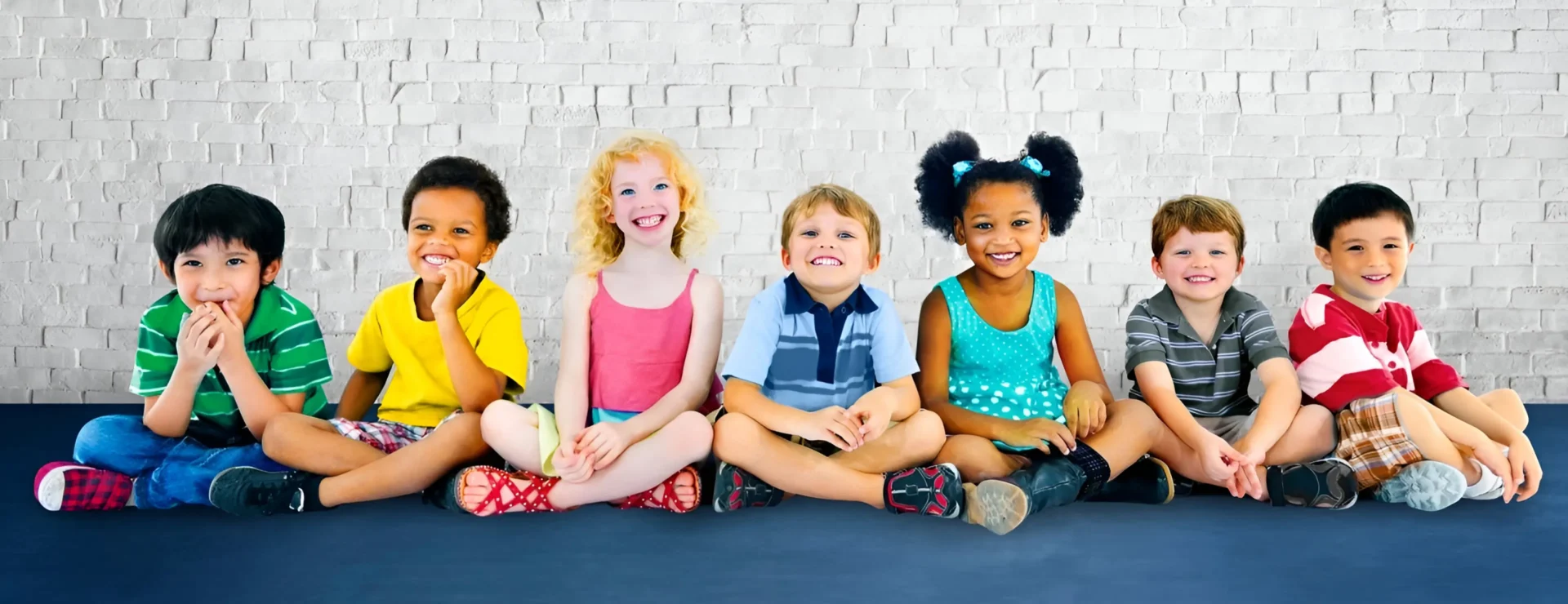 A group of children sitting on the ground.