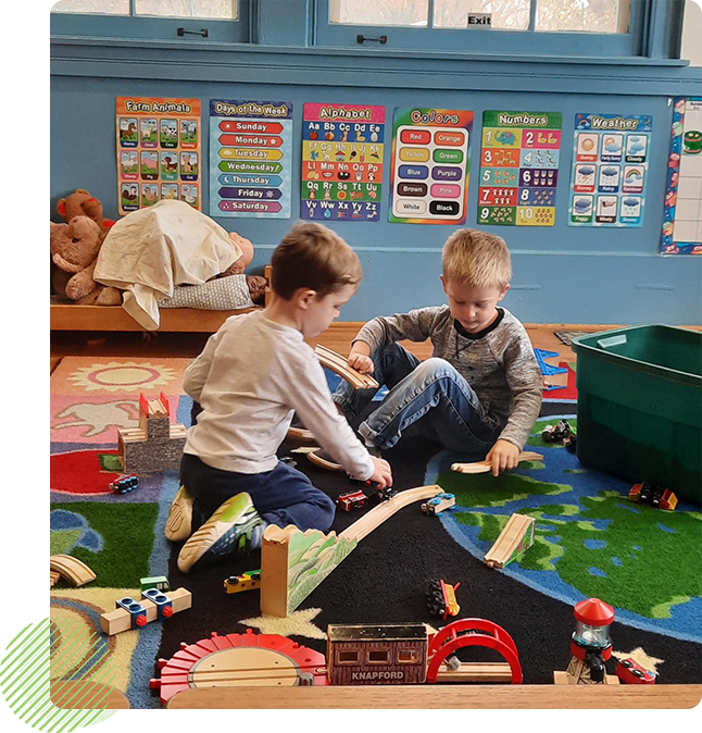 Two young boys playing with toys in a room.